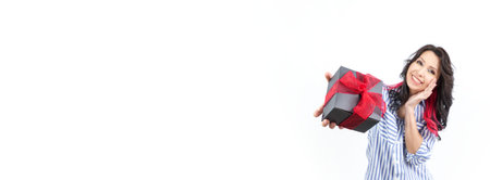 A cheerful woman looks at the camera with a warm smile, wearing a trendy casual outfit. Her long, dark hair enhances the soft, neutral background, creating a joyful and inviting atmosphere.の写真素材