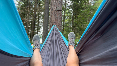 Enjoying a peaceful moment in a hammock, nestled between tall trees, highlighting the tranquility...