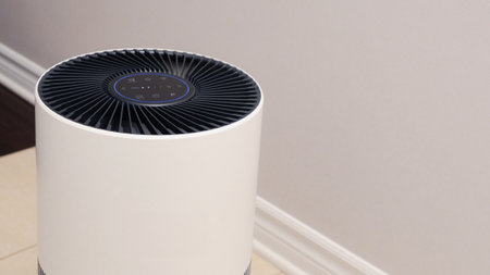 Sleek Modern Tall Air Purifier with Black Fan on Beige Tile Floor in Stylish Room.の写真素材