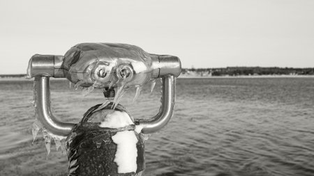 Frozen View Through a Public Telescope Sights Overlooking Icy Lake.の写真素材