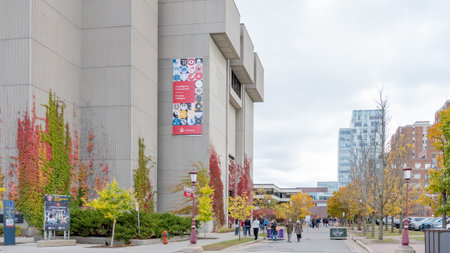 Ottawa ON, Canada - October 25, 2025: uOttawa University features colorful autumn leaves and contemporary buildings, with students strolling along the pathway, enhancing the vibrant campus lifeのeditorial素材