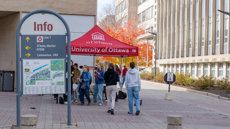 Ottawa ON, Canada - October 25, 2025: Diverse group of students stands under red tent at University...