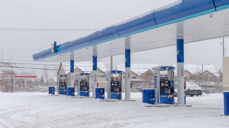 Gatineau QC, Canada - November 30, 2025: Gas station featuring fuel pumps surrounded by snow during...