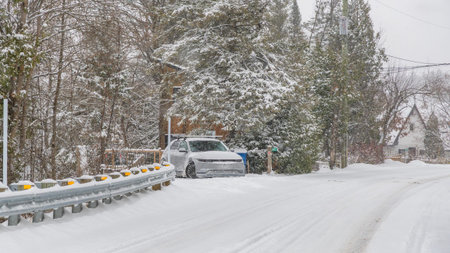 Gatineau QC, Canada - November 30, 2025: Snowy road features a parked car next to a guardrail,...