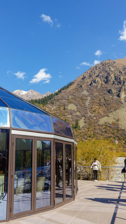 Bishkek, Kyrgyzstan - September 29, 2024: Modern glass structure in Ala-Archa Nature Park surrounded by majestic Tian Shan mountains, creating a peaceful and scenic environmentのeditorial素材