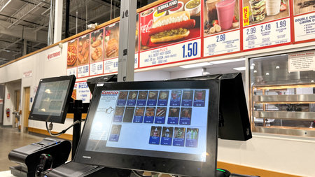 St Augustine FL, USA - March 07, 2026: Costco food court checkout area with digital menu board...