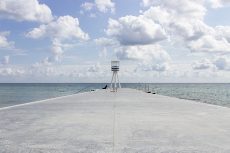 Beautiful scenery of Klampenborgs (Denmark) bridge and lighthouse at the beach on a sunny day with some clouds on the seaside.の写真素材