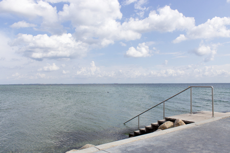 Beautiful scenery of Klampenborgs (Denmark) bridge at the beach on a sunny day with some clouds on the seaside.の写真素材