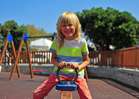 Little boy on swing at kid's playground, summer sceneの写真素材