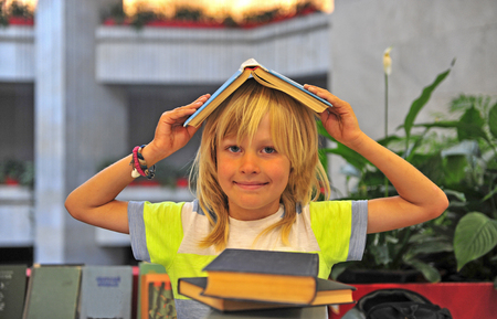 Happy kid with books at libraryの写真素材