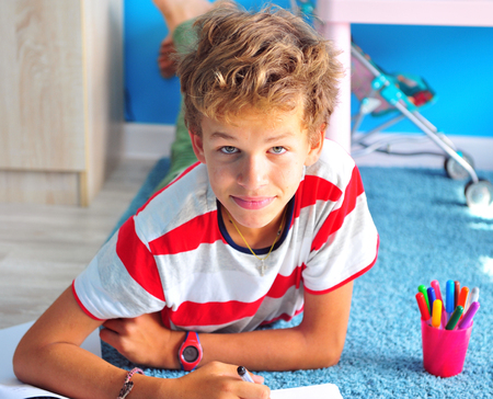 Boy drawing with felt pens at homeの写真素材