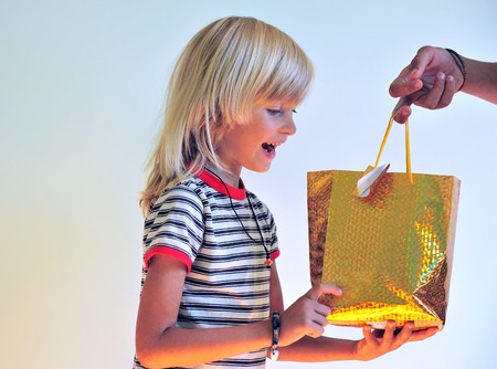 Happy kid getting present in the golden bagの写真素材