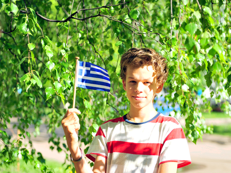 Cheerful teenager with flag of Greece outdoorsの写真素材