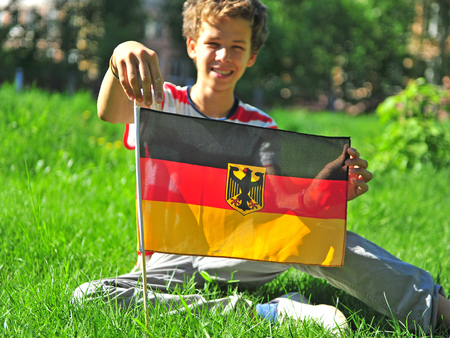 Happy child with national flag of Germany outdoorsの写真素材