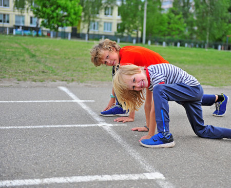 Two kids ready to run on the track