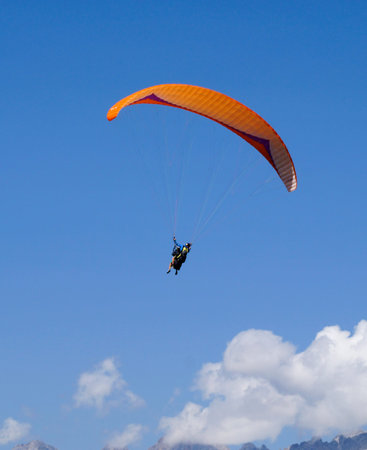 Paraglider flying in the blue sky on a sunny day