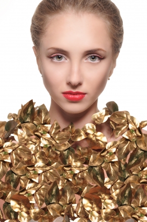 portrait of blonde girl on the neck clad in gold leaf on a white backgroundの写真素材