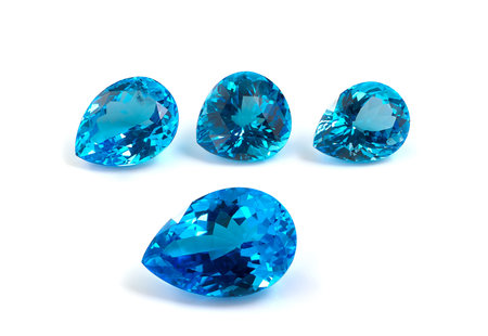 Four pear shape topaz gemstones on white background 