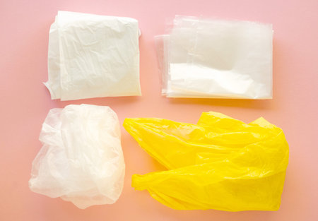 Various plastic bags on a pink background.