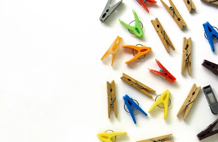 Wooden and multicolored plastic clothespins on a white background.の写真素材