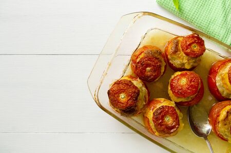 Baked tomatoes stuffed with minced chicken and cheese on a white background.の写真素材