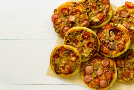 Mini pizza with sausages and tomatoes on a light background.の写真素材
