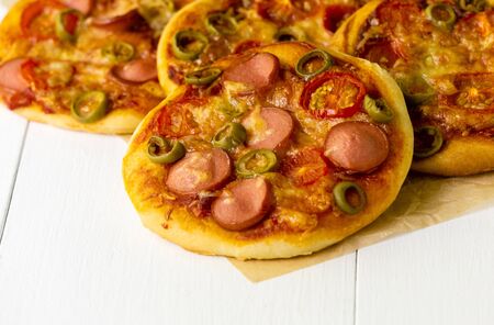 Mini pizza with sausages and tomatoes on a light background.の写真素材