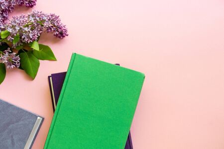 Hardback books with branch of lilac on a pink background.の写真素材