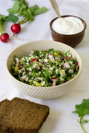 Salad with radish, eggs and dill on a white fabric background.の写真素材