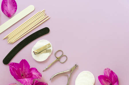 Flat lay of manicure accessories with flowers on a lilac background. Space for textの写真素材