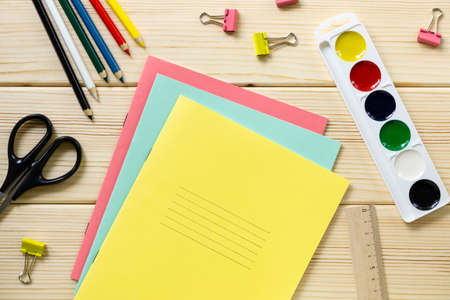 Back to school flat lay. Stationery on a light wooden background, top view.の写真素材