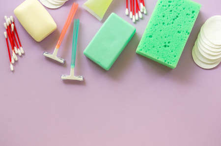 Flat lay of bath and hygiene products. Razors, soap bars and washcloth on a lilac background. Space for text.の写真素材