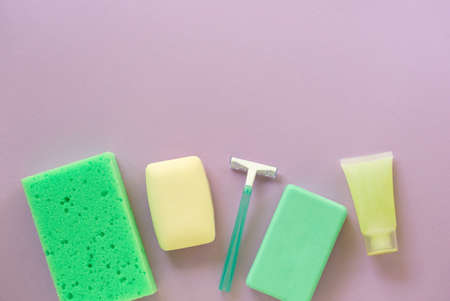 Flat lay of bath and hygiene products. Razor, soap bar and washcloth on a lilac background. Space for textの写真素材