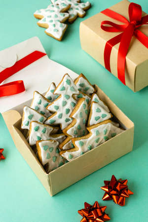 Christmas gingerbread cookies in the shape of trees in box on mint backgroundの写真素材