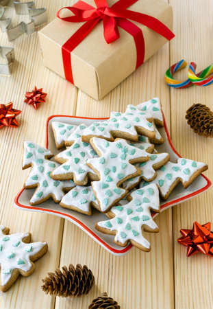 Christmas and new year baking. Homemade gingerbread cookies in the shape of trees in plate on wooden backgroundの写真素材