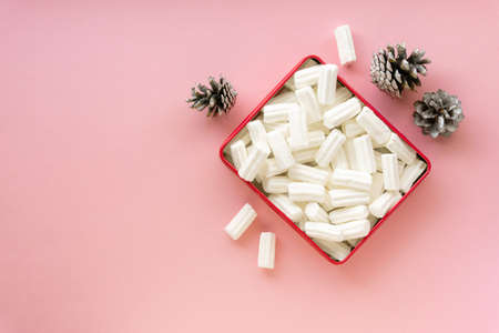 Heap of white marshmallows in box on pink background, space for text.の写真素材