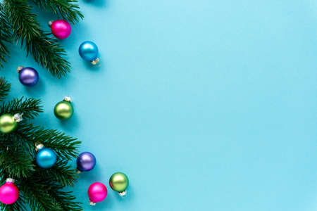 Christmas or new year flat lay of decorations. Multicolored balls with fir branches on a blue background. Space for text.の写真素材