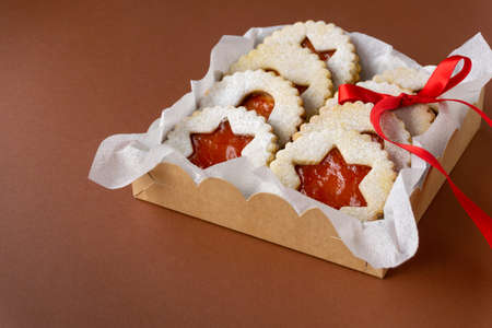 Traditional austrian christmas linzer cookies with jam in box on brown background.の写真素材