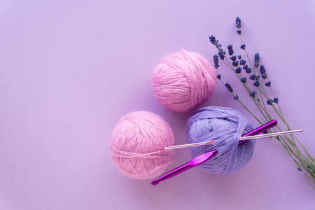 Flat lay of colored yarn balls for crocheting with lavender on a lilac background, top view.の写真素材