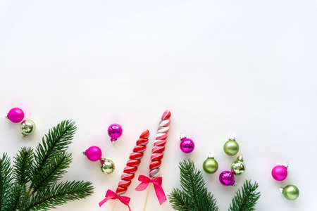 Christmas flat lay of lollipops, balls and fir branches on white background. Space for text.の写真素材