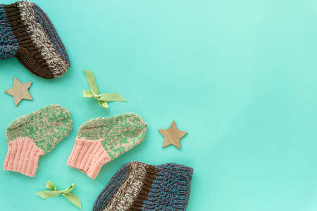 Flat lay of baby knitted socks for boy and girl on mint background, copyspace.の写真素材