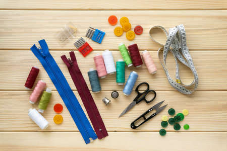 Flat lay of accessories for tailor. Set of sewing supplies on wooden background.の写真素材