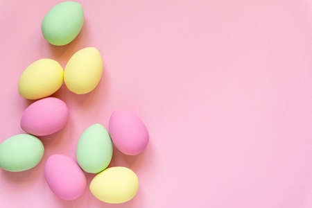 Easter flat lay. Eggs painted in pastel colors on pink background, space for textの写真素材