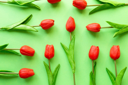 Flat lay of red tulips on green background, top viewの写真素材