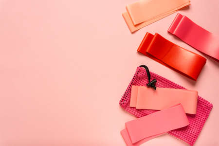 Flat lay of pink fitness bands on colored background, space for textの写真素材