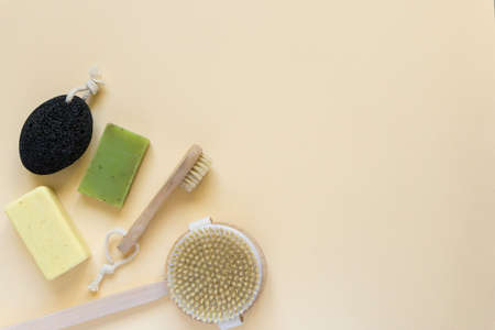 Flat lay of bath products and items. Soap and massage brushes on beige background, space for textの写真素材