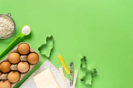 Ingredients for making easter cookies in the shape of bunny on green background, copyspace.の写真素材