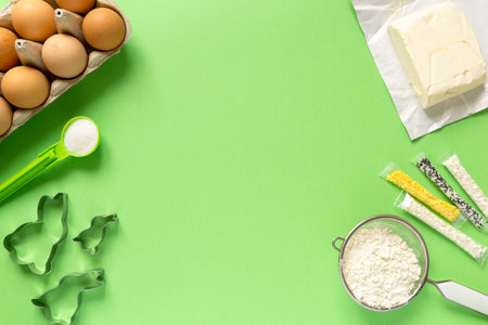 Ingredients for making easter cookies in the shape of bunny on green background, copyspace.の写真素材