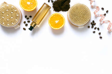 Flat lay of anti-cellulite care products. Dry massage brushes, coffee scrub and oil on white background, space for text.の写真素材
