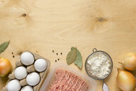 Ingredients for cooking dumplings. Minced meat, eggs, flour and spices on wooden background, top...